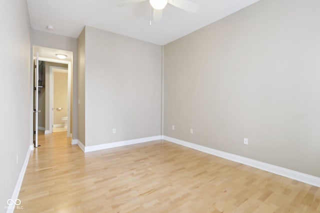 spare room featuring baseboards, ceiling fan, and light wood-style floors