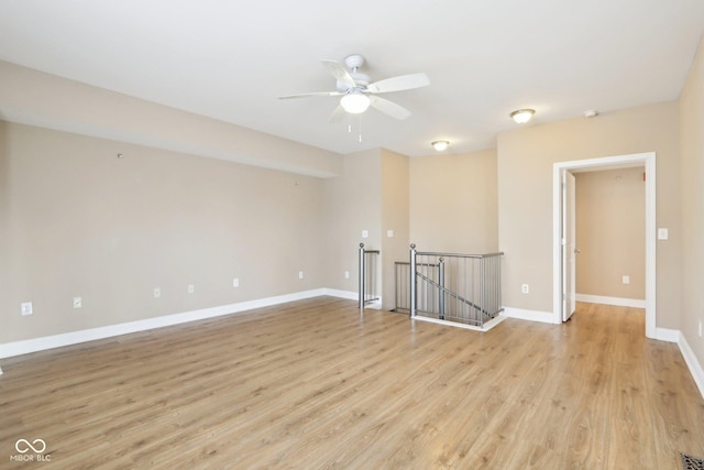 empty room with baseboards, light wood-style floors, and ceiling fan