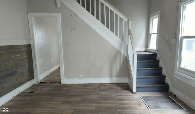staircase featuring baseboards and wood finished floors