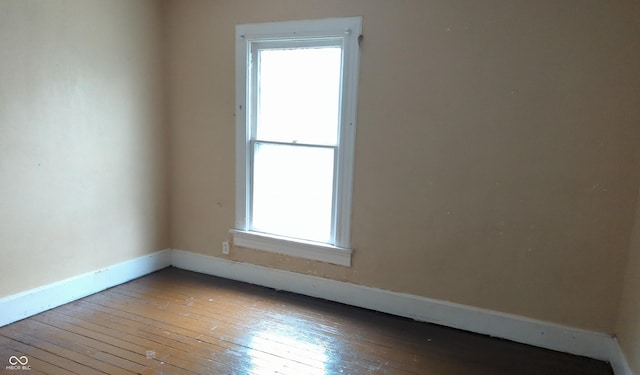 unfurnished room with hardwood / wood-style floors and baseboards