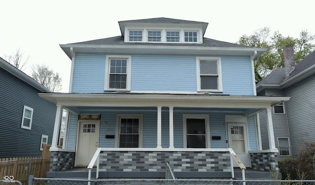 american foursquare style home with covered porch and fence