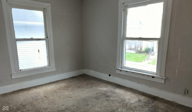 carpeted spare room featuring baseboards