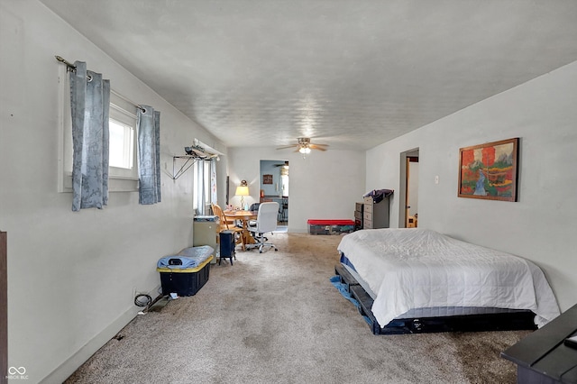 carpeted bedroom featuring baseboards and a ceiling fan