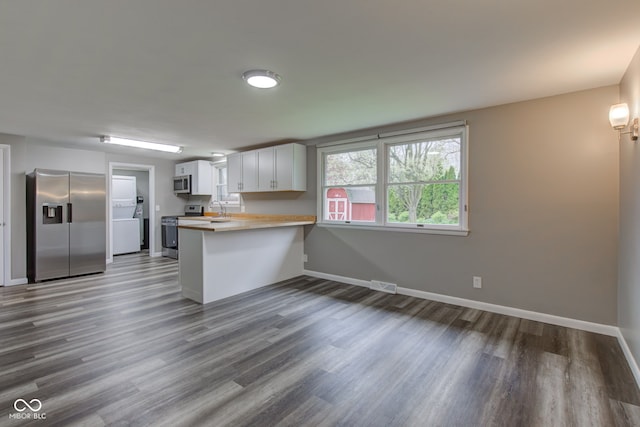 2205 Lafayette Rd, Crawfordsville, IN 47933 - kitchen with visible vents, dark wood-type flooring, baseboards, a peninsula, and appliances with stainless steel finishes