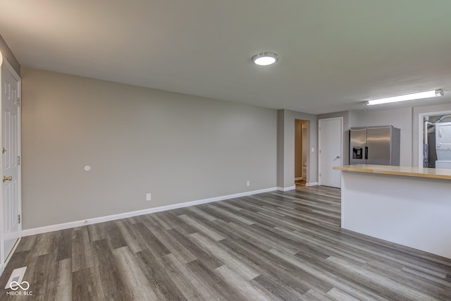2205 Lafayette Rd, Crawfordsville, IN 47933 - unfurnished living room with dark wood-type flooring, stacked washer and dryer, and baseboards