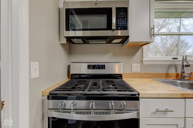 2205 Lafayette Rd, Crawfordsville, IN 47933 - kitchen with wood counters, stainless steel appliances, white cabinets, and a sink