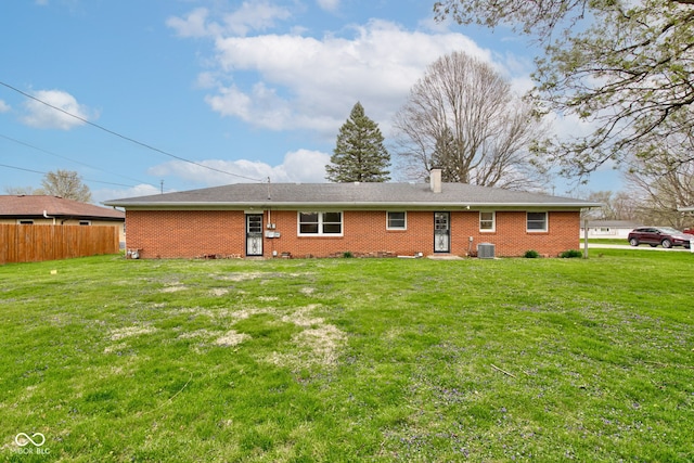 2205 Lafayette Rd, Crawfordsville, IN 47933 - rear view of house with central air condition unit, a chimney, a lawn, fence, and brick siding