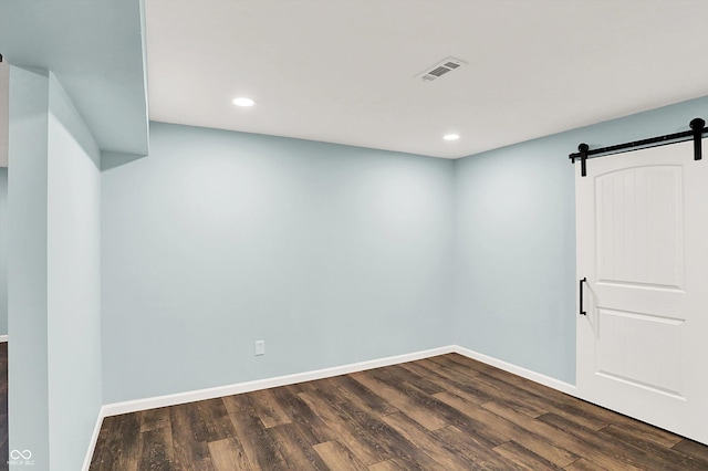16491 Wheatley Ct, Fishers, IN 46040 - spare room with a barn door, dark wood-style flooring, recessed lighting, and baseboards
