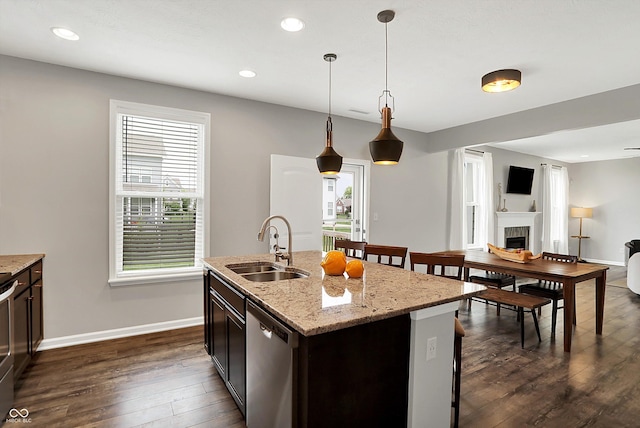 16491 Wheatley Ct, Fishers, IN 46040 - kitchen with a sink, stainless steel appliances, dark wood-style floors, a tiled fireplace, and recessed lighting
