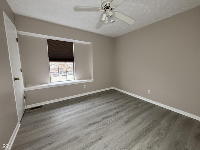 unfurnished room featuring wood finished floors, a textured ceiling, baseboards, visible vents, and ceiling fan