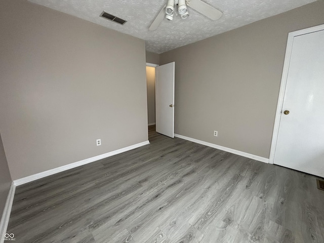 unfurnished bedroom with baseboards, visible vents, and wood finished floors