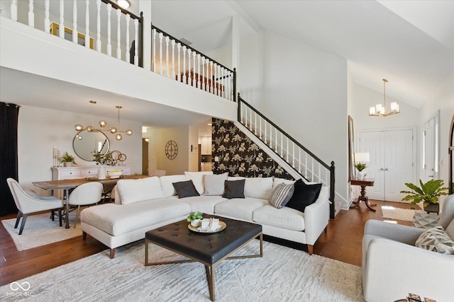 living room featuring stairs, wood finished floors, a chandelier, and high vaulted ceiling