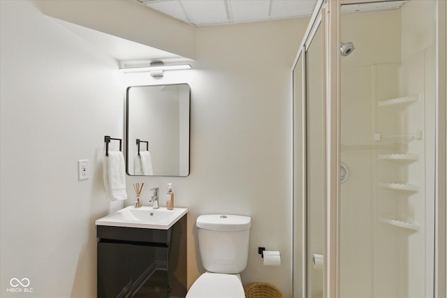 bathroom with toilet, a shower stall, and vanity