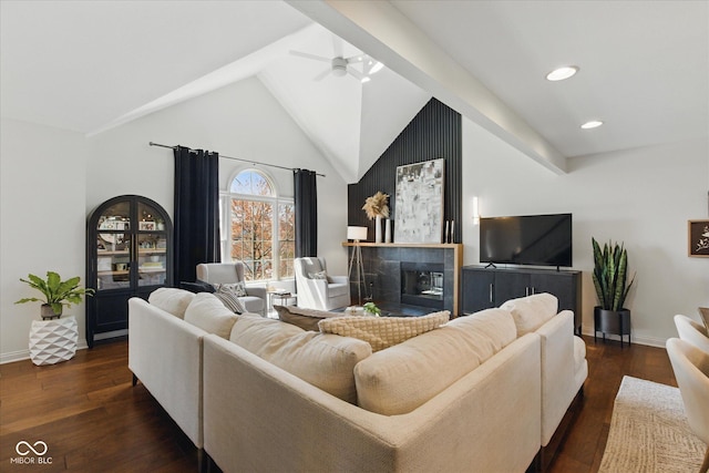 living area with ceiling fan, baseboards, lofted ceiling with beams, a glass covered fireplace, and dark wood-type flooring