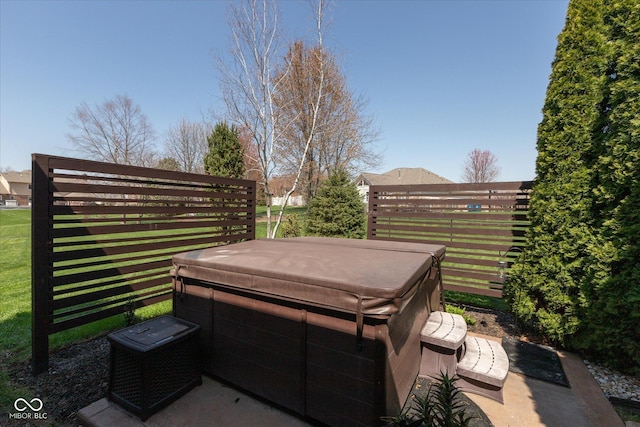 view of patio featuring fence and a hot tub