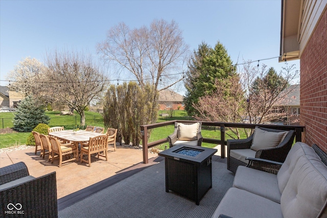 view of patio / terrace with outdoor dining space and an outdoor living space with a fire pit