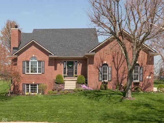 ranch-style home with a shingled roof, a chimney, a front lawn, and brick siding