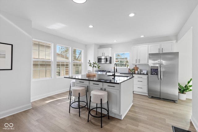 625 N Parker Ave, Indianapolis, IN 46201 - kitchen featuring appliances with stainless steel finishes, a sink, dark countertops, white cabinets, and light wood-type flooring
