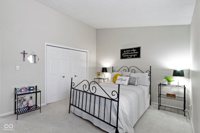 carpeted bedroom featuring baseboards and a closet