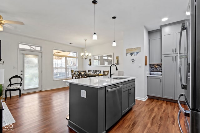 kitchen with a sink, dark wood-style flooring, stainless steel appliances, and gray cabinets