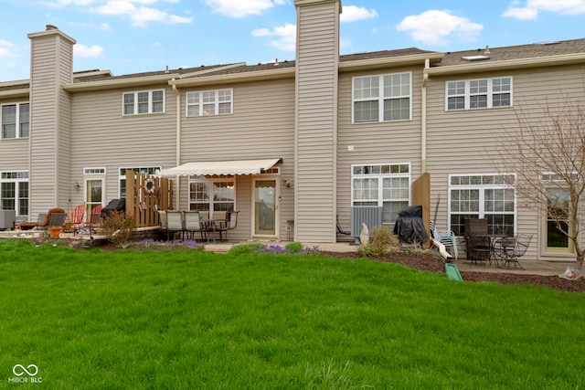 back of house with a patio, a lawn, central AC, and a chimney