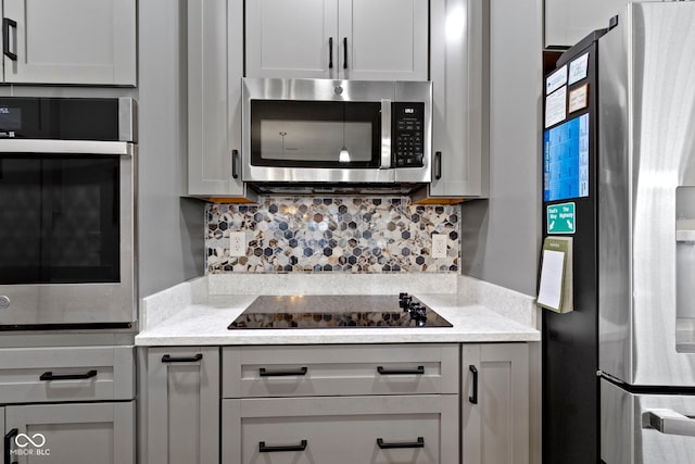 kitchen with gray cabinets, tasteful backsplash, and stainless steel appliances