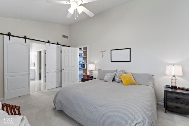 bedroom featuring a barn door, light carpet, visible vents, a ceiling fan, and high vaulted ceiling