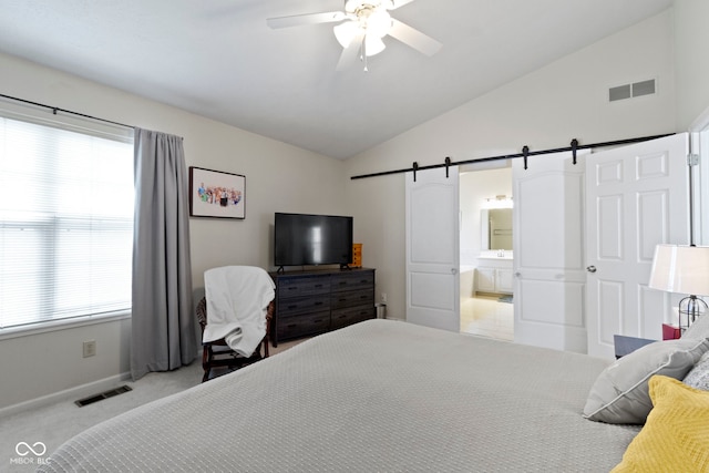 bedroom featuring lofted ceiling, visible vents, baseboards, and a barn door