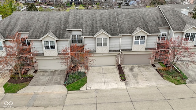 townhome / multi-family property with a garage, a shingled roof, driveway, and a residential view