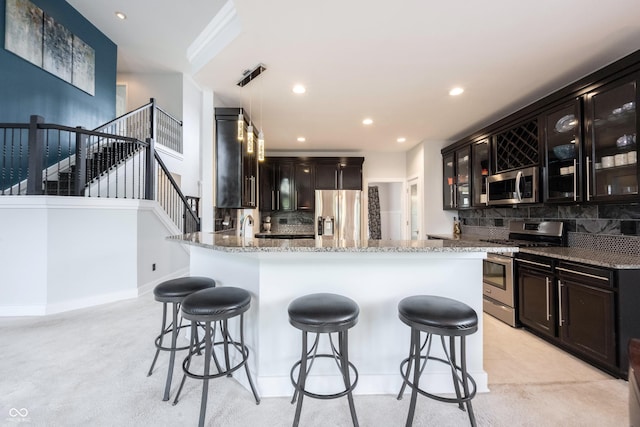 kitchen featuring glass insert cabinets, appliances with stainless steel finishes, decorative backsplash, and light stone counters