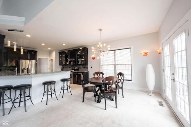 dining room featuring recessed lighting, an inviting chandelier, light carpet, and a wealth of natural light