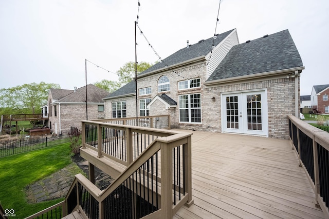 deck with a lawn, fence, and french doors