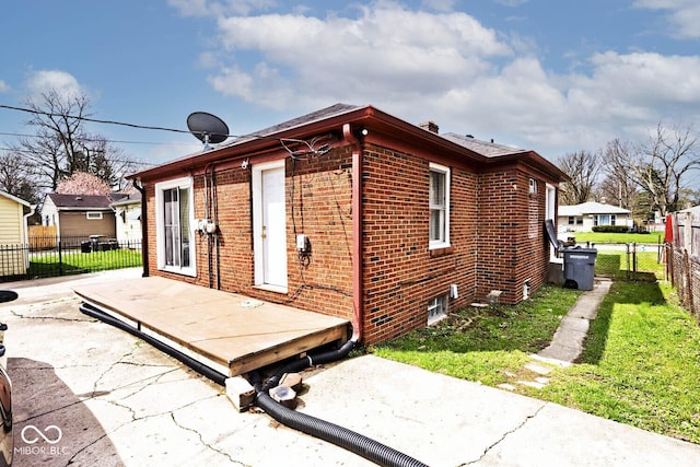 rear view of property featuring a patio area, brick siding, a deck, and fence