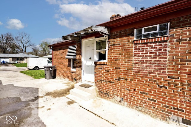 doorway to property featuring brick siding