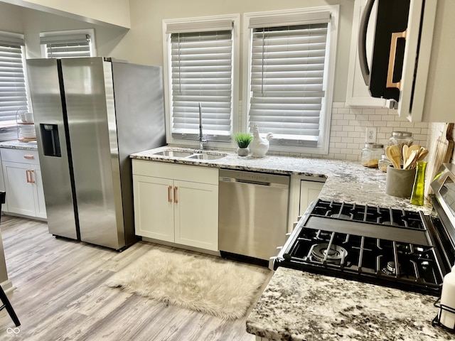 4205 Rookwood Ave, Indianapolis, IN 46208 - kitchen with tasteful backsplash, a sink, appliances with stainless steel finishes, light stone countertops, and light wood-style flooring