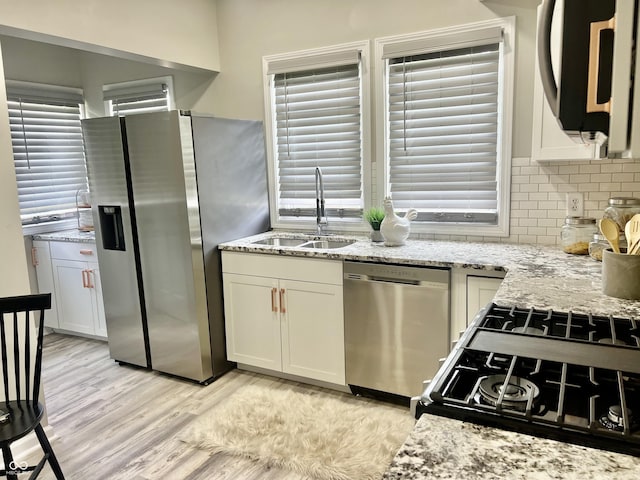 4205 Rookwood Ave, Indianapolis, IN 46208 - kitchen featuring tasteful backsplash, light stone countertops, stainless steel appliances, light wood finished floors, and a sink