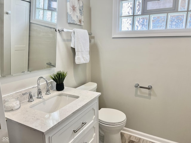 4205 Rookwood Ave, Indianapolis, IN 46208 - bathroom featuring toilet, vanity, baseboards, and plenty of natural light