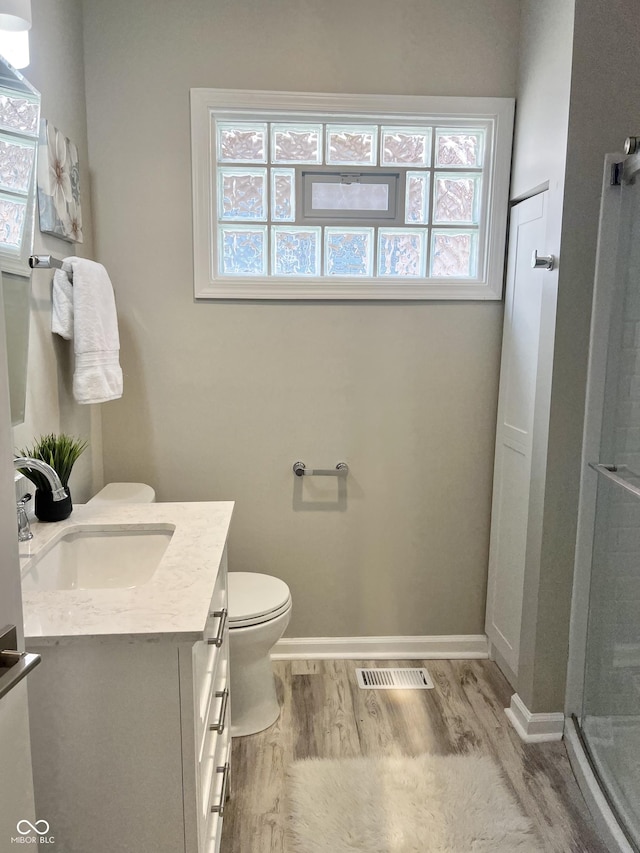 4205 Rookwood Ave, Indianapolis, IN 46208 - full bathroom featuring vanity, visible vents, toilet, wood finished floors, and a stall shower