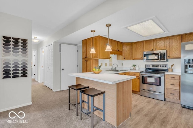 1632 Queensbridge Sq Unit 7, Indianapolis, IN 46219 - kitchen featuring stainless steel appliances, a peninsula, a breakfast bar area, light countertops, and hanging light fixtures