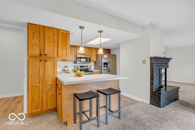 1632 Queensbridge Sq Unit 7, Indianapolis, IN 46219 - kitchen with appliances with stainless steel finishes, a peninsula, a sink, light countertops, and a breakfast bar area