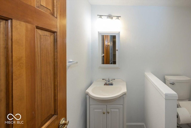 half bath featuring toilet and vanity