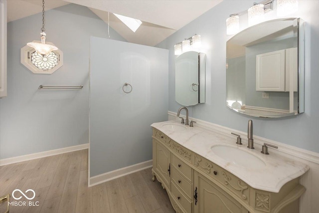 full bath with wood finished floors, vaulted ceiling with skylight, double vanity, and a sink