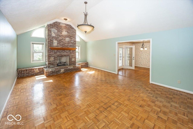 unfurnished living room featuring baseboards, a notable chandelier, a fireplace, and vaulted ceiling
