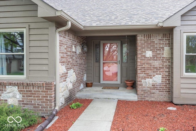 entrance to property with brick siding and roof with shingles