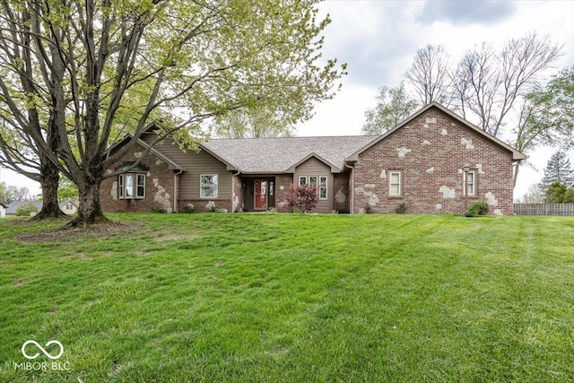ranch-style house featuring fence, a front yard, and brick siding