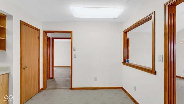 interior space with light carpet and baseboards