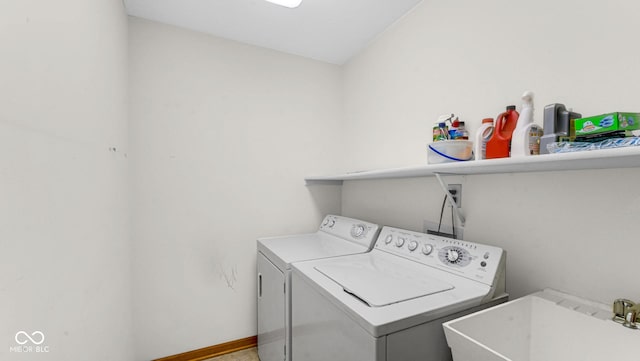 laundry area featuring laundry area, separate washer and dryer, a sink, and baseboards