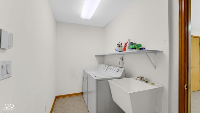 laundry area with washer and clothes dryer, baseboards, laundry area, and a sink