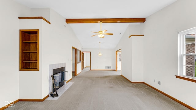 unfurnished living room featuring a tiled fireplace, beam ceiling, baseboards, and a ceiling fan