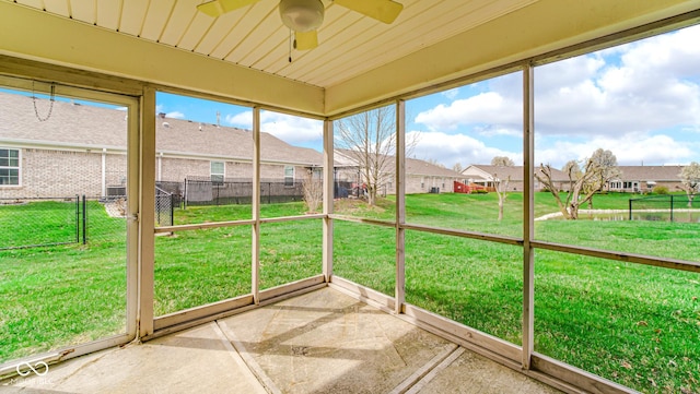 unfurnished sunroom with a residential view and ceiling fan